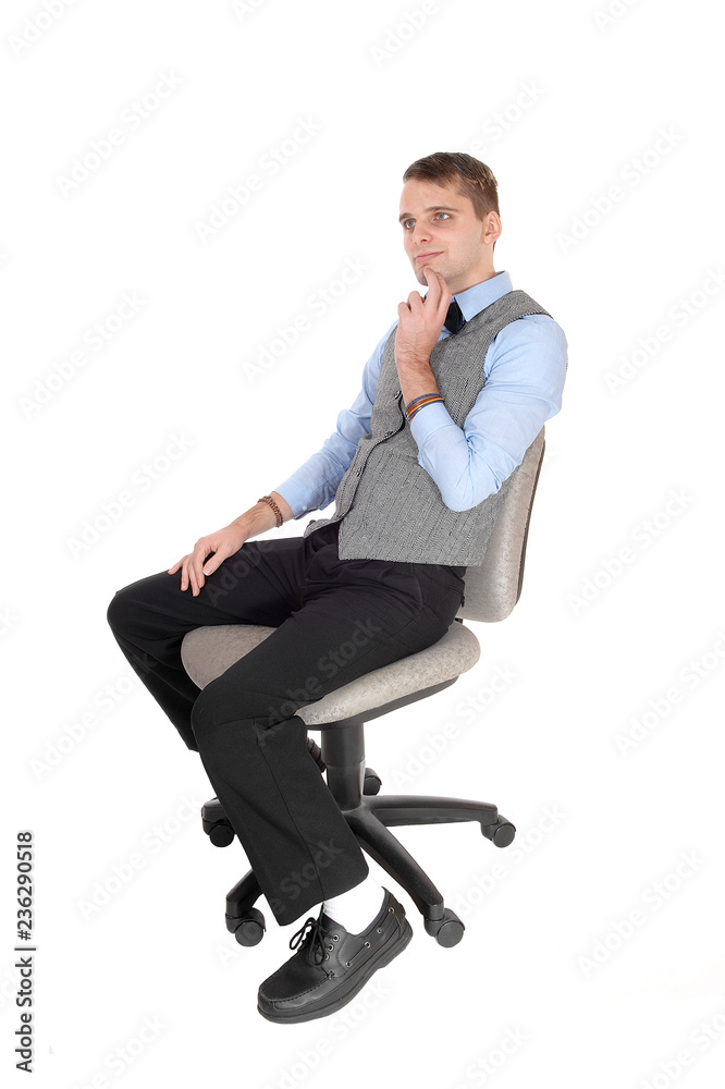 Man sitting in dress pants and vest, thinking Man sitting in dress pants and vest, thinking