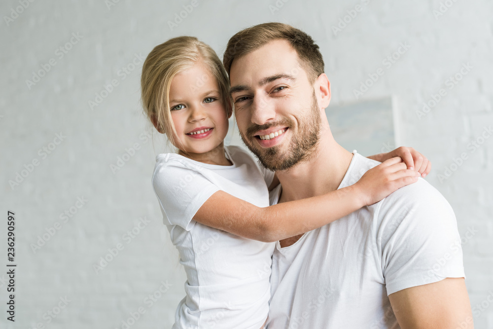 happy father and cute little daughter hugging and smiling at camera happy father and cute little daughter hugging and smiling at camera