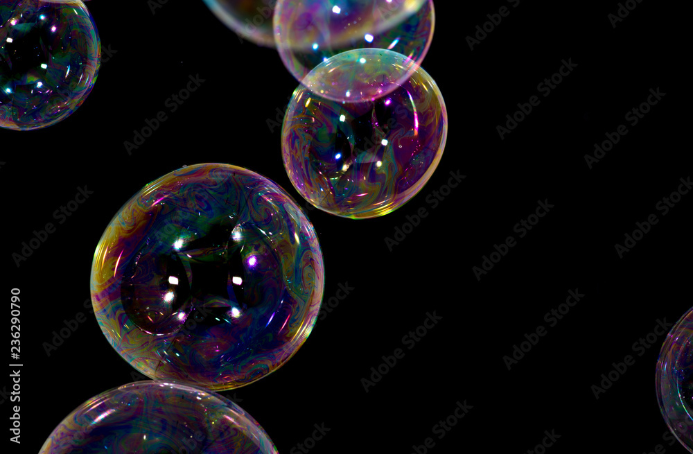 Naklejka premium Multicolored soap bubbles close up on a black background 