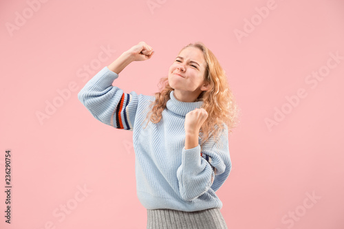 I won. Winning success happy woman celebrating being a winner. Dynamic image of caucasian female model on pink studio background. Victory, delight concept. Human facial emotions concept. Trendy colors