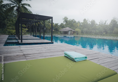 Green Towel on the sun bed near swimming pool. Vintage tone © nuttawutnuy