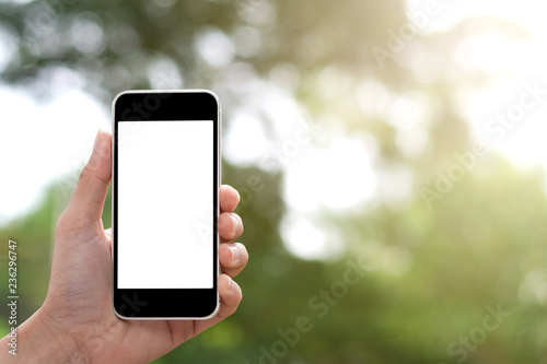 Hand holding smartphone black color on bokeh background