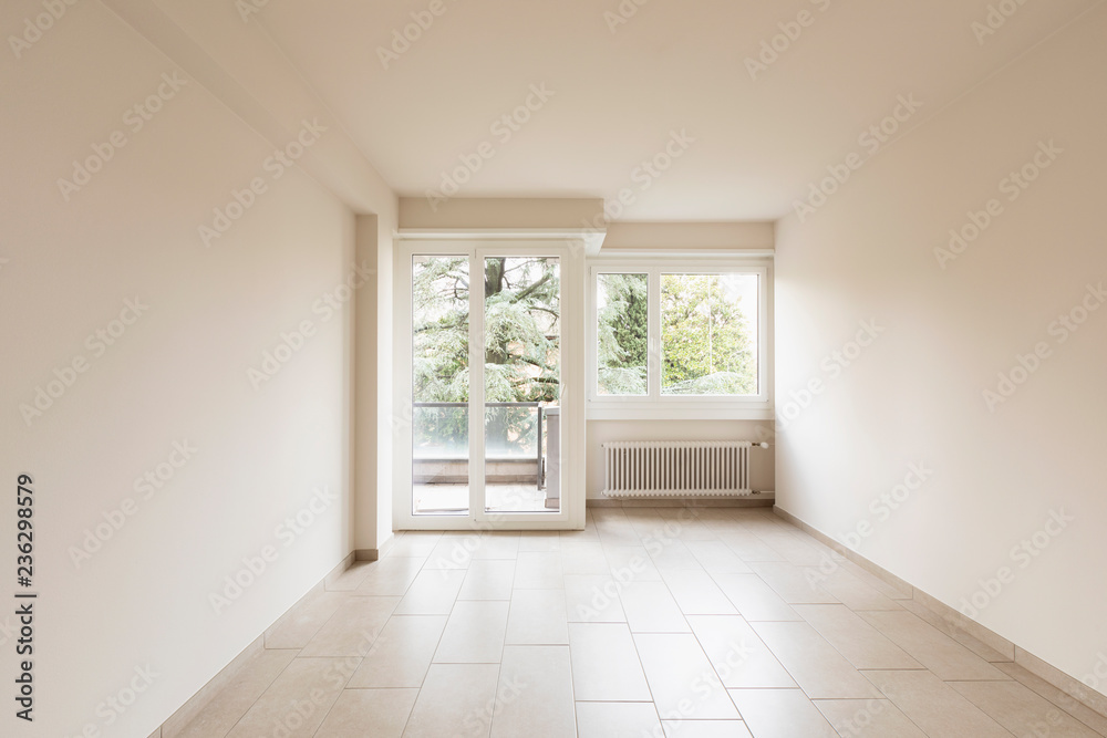 Fototapeta premium Empty room with radiators and large windows overlooking nature