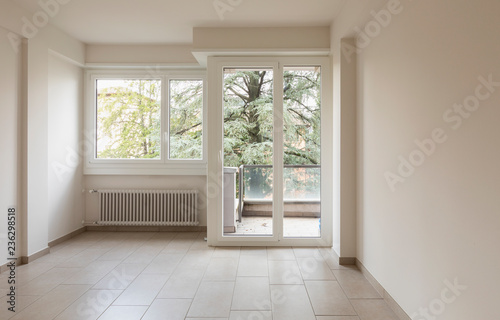 Empty room with radiators and large windows overlooking nature