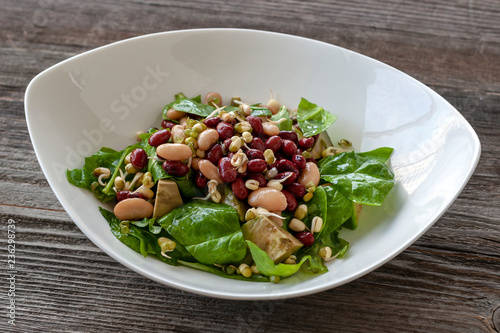 Bean salad with vitamins. Salad with spinach, arugula, avocado, sprouted seeds and beans.