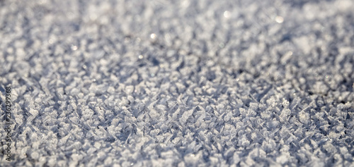 Frozen crystals on frost and snow in the sun outdoors. Empty background for copy space.