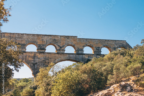 Beautiful view of a fragment of the Pont du Gard in the fall against the blue sky