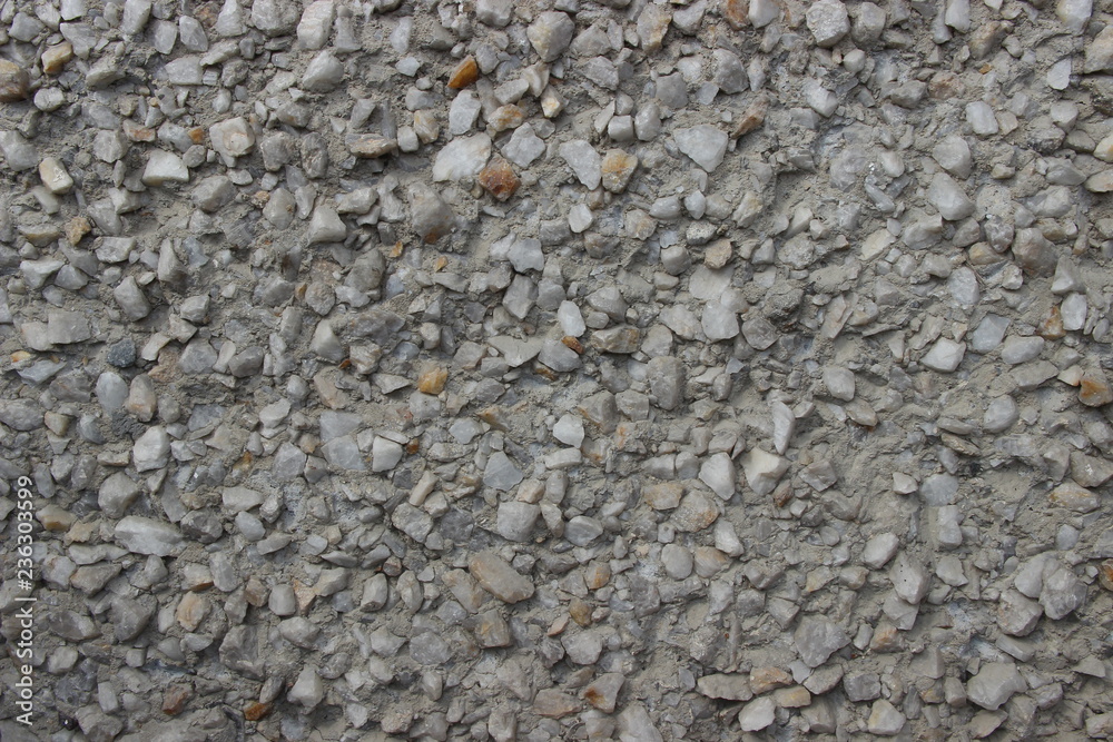 The wall consists of small gray stones, arranged in a chaotic order The wall consists of small gray stones, arranged in a chaotic order