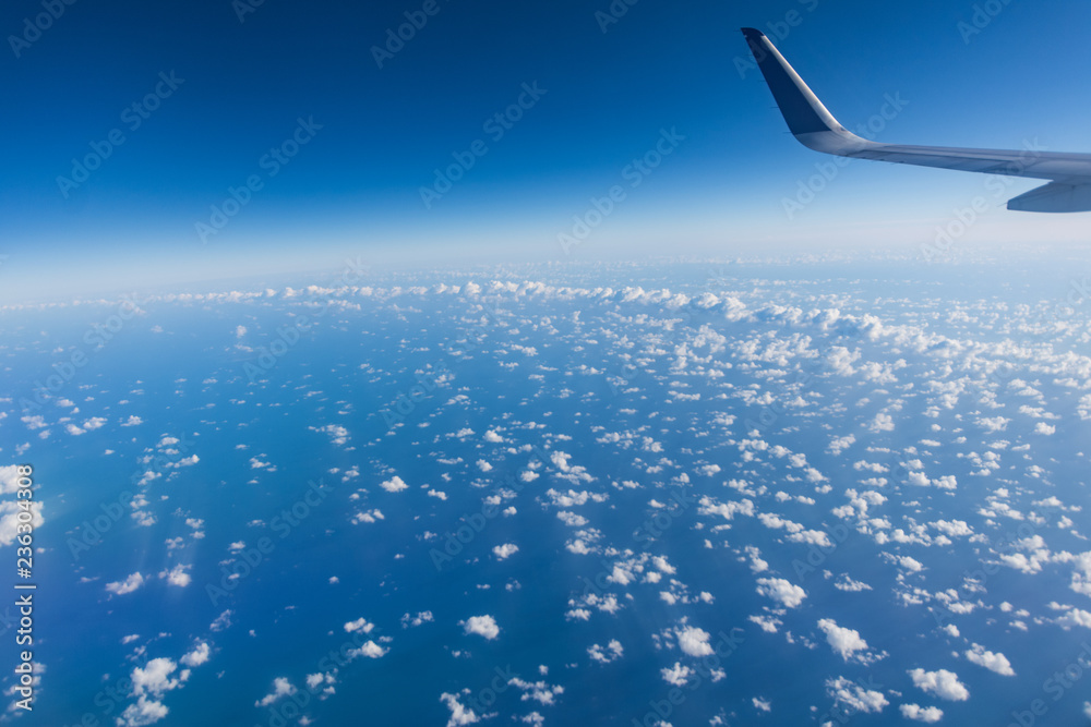 wing of an airplane flying above clouds wing of an airplane flying above clouds