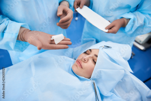 Top view of plastic surgeon preparing bandage for patient after surgery
