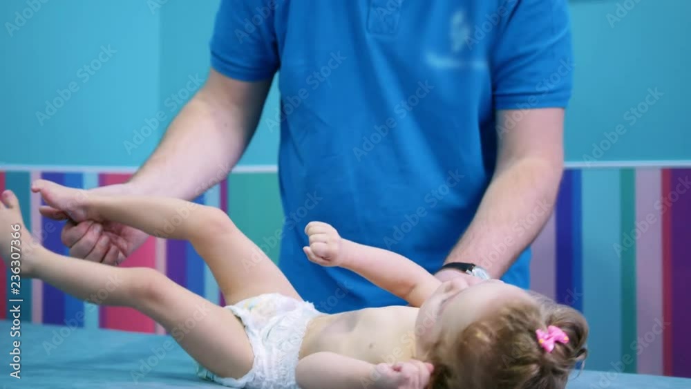 Medicine clinic. An occupation with a baby with cerebral palsy disorder. Doing physical exercises on legs Medicine clinic. An occupation with a baby with cerebral palsy disorder. Doing physical exercises on legs
