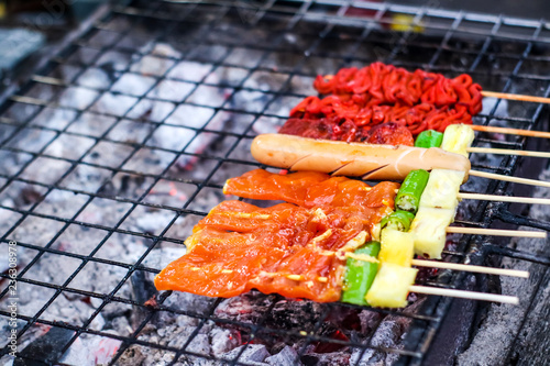 Beef, pork, beef, chicken and sausage are cooked on the stove photo