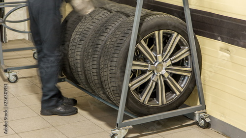 Car mechanic put tires from trolley to rack in auto repair service timelapse.