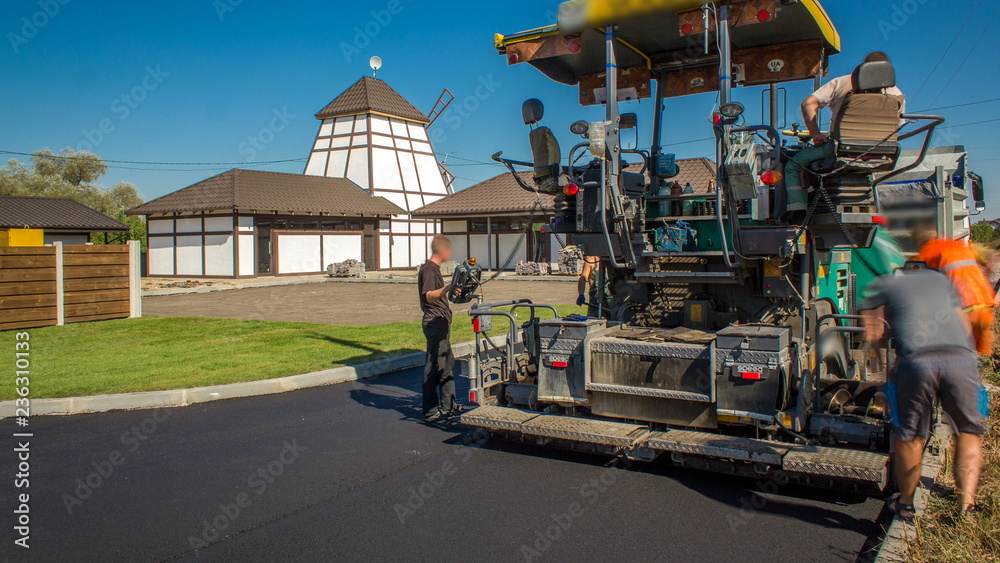 Workers operating asphalt paver machine during road construction and repairing works timelapse Workers operating asphalt paver machine during road construction and repairing works timelapse