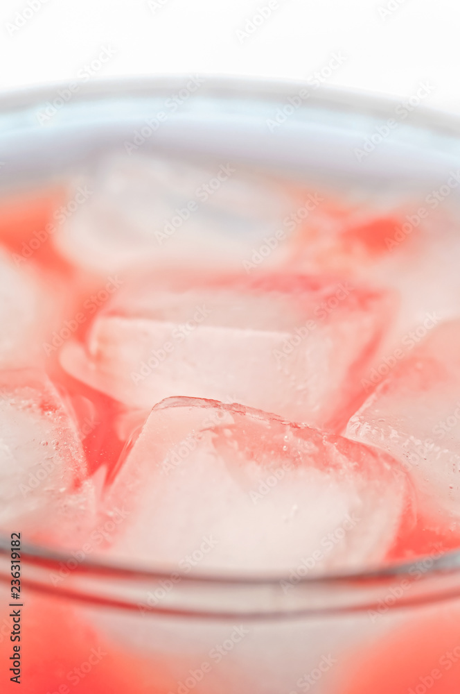 Orange drink closeup with ice cubes background