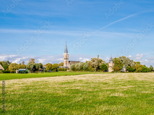 Church tower of village of Cornwerd and grassland in province of Friesland, Netherlands © TasfotoNL