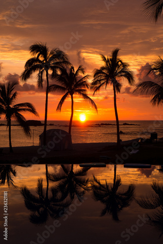 Tropical paradise sunset reflecting on a swimming pool and sandy beach in Punta Mita, Mexico photo