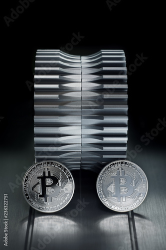 Bitcoin Silver coin stand on metallic surface with gearwheel in the background photo