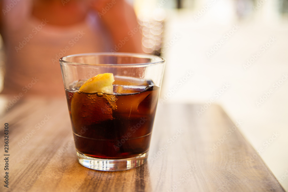 Glass of cola with ice and lemon on the table. Street cafe. Soft focus. Copy space Glass of cola with ice and lemon on the table. Street cafe. Soft focus. Copy space