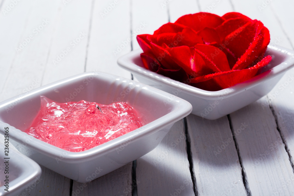 skin care creams and rose on white wooden table
