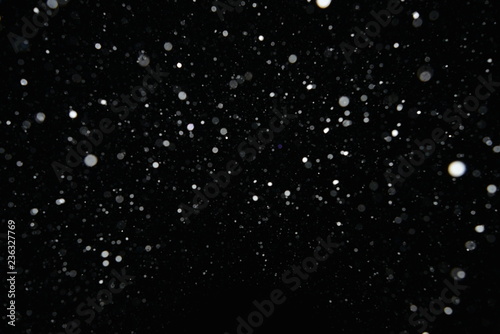 The texture of the flying snow on a black background.