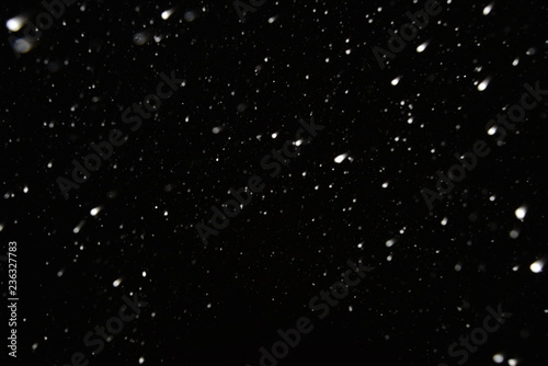 The texture of the flying snow on a black background.