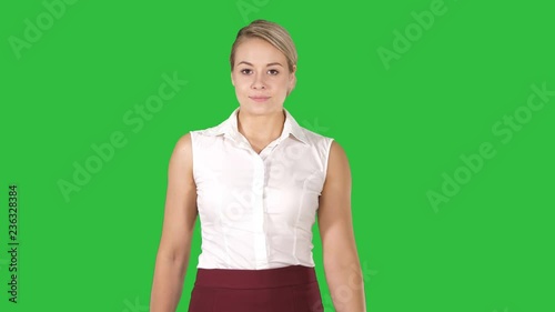 Formaly dressed young woman walking to the camera on a Green Screen, Chroma Key. photo