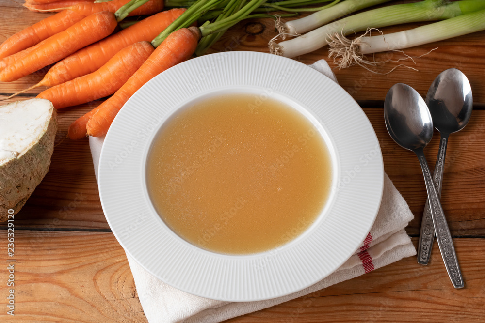 Chicken bone broth in a plate, top view Chicken bone broth in a plate, top view