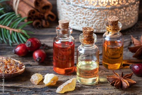 Fototapeta Naklejka Na Ścianę i Meble -  Christmas collection of essential oils with frankincense, myrrh, rose hips, cinnamon
