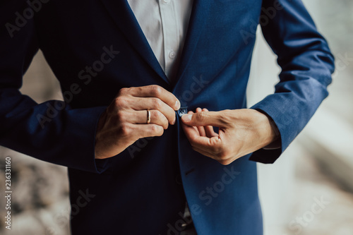 The morning of groom.The man adjusts his jacket  groom in a jacket.Wedding day.