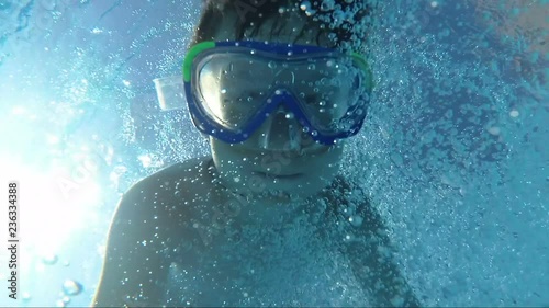 Happy Boy Jumps Into The Swimming Pool And Swims Under Water, outdoors photo