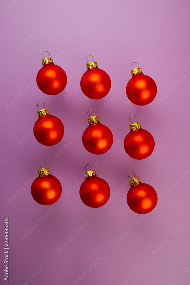 Christmas red balls lie on a purple background. Christmas red balls lie on a purple background.