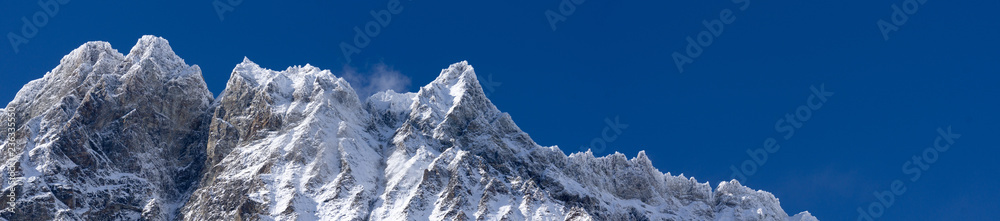 Panoramic landscape with a chain of mountain in a clean blue sky with snow in the italian winter
