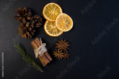 Christmas Tree Pine Branches with dry oranges. cinnamon, anise, pine on a dark background.