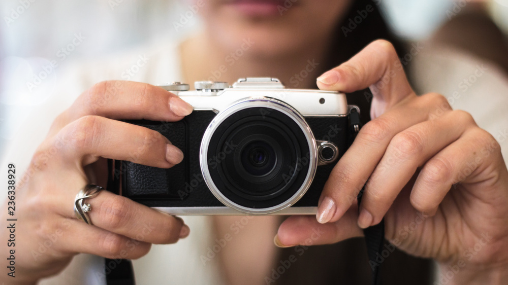 Young woman holds a compact photo camera Young woman holds a compact photo camera