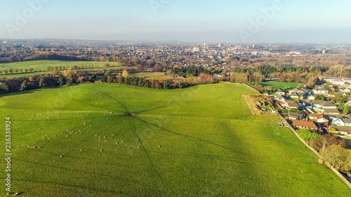 Aerial image over a green field with grazing sheep to the townscape of Coatbridge. photo