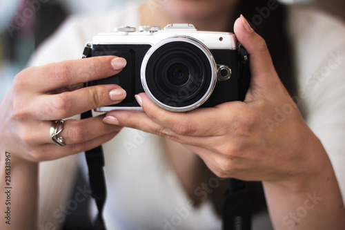 Young woman holds a compact photo camera