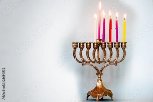 Fifth day of Hanukkah with burning Hanukkah colorful candles in Menorah (traditional Candelabra) .Chanukkah-jewish holiday. Each night, another candle is added. Copy space for text.
