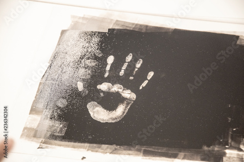 Taking fingerprints with a black paint hand