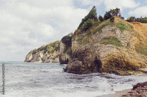 Waves on the beach. Waves hitting a rocky hill. Waves hitting rocks on shore. Rocky hill on the beach. Beach in Istanbul, Ağva, Kilimli