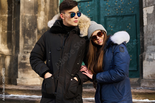 A trendy young couple walks in the city at christmastime