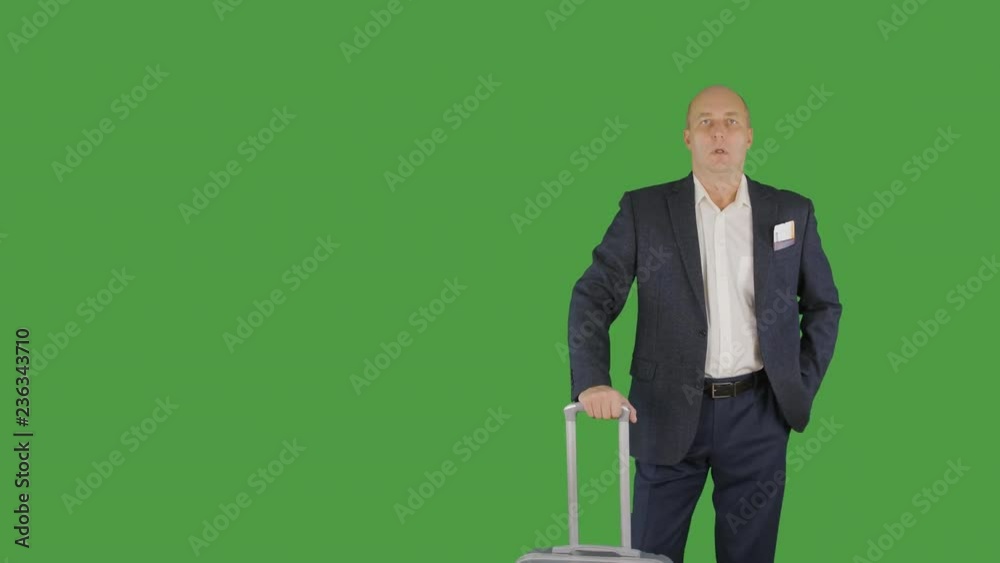 Businessman looking at smartphone while waiting for business trip with luggage Businessman looking at smartphone while waiting for business trip with luggage