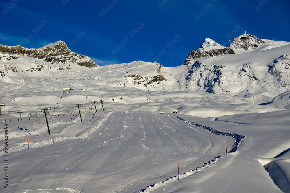 Ski slope on an afternoon of blue sky.