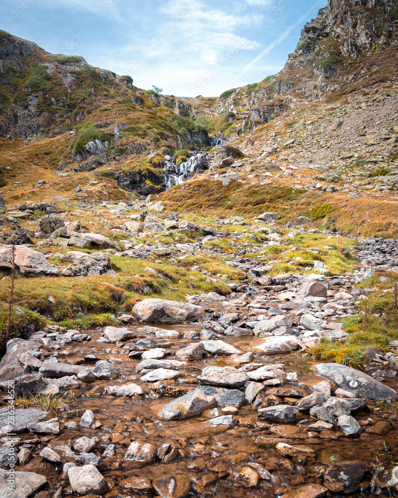 An hiking trail in the iconic Ossau valley in the french pyrennees pass by a vivid stream