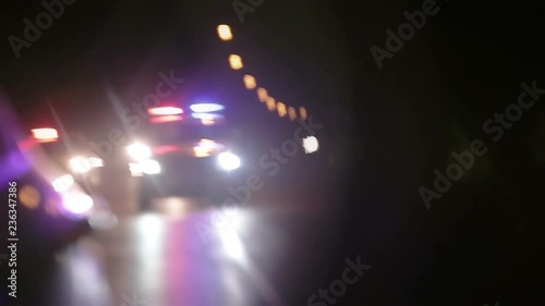 Police lights flashing in side view mirror of car