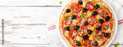 Pizza with tomatoes, mozzarella cheese, olives, corn and basil. Traditional italian cuisine. Top view. Banner