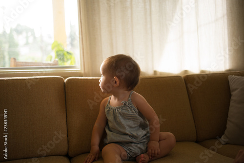 Baby girl sitting on sofa