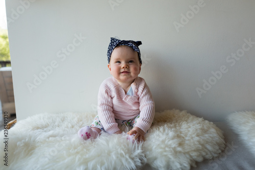 Baby girl sitting on bed