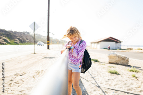 Girl leaning on handrail by highway