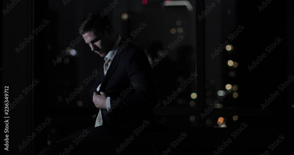 Businessman finishing work lat at night and checking smartphone 
